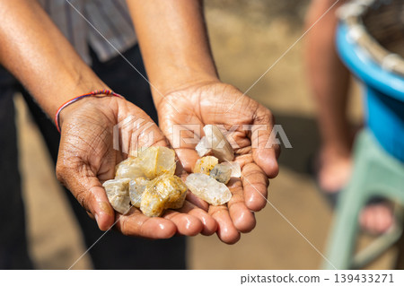 Close-up of hands hold raw natural gemstones, display earth elements, symbolize wealth, nature, and geological discovery. Sri Lanka island in Asia. Close-up of hands hold raw natural gemstones, display earth elements, symbolize wealth, nature, and geological discovery. Sri Lanka island in Asia. 139433271