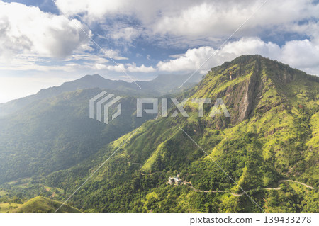 Ella rock mountain, view from Little Adam's Peak in Sri Lanka. Verdant Mountain Landscape with Majestic Peaks, Lush Valleys, and Serene Sky on a Bright Day Ella rock mountain, view from Little Adam's Peak in Sri Lanka. Verdant Mountain Landscape with Majestic Peaks, Lush Valleys, and Serene Sky on a Bright Day 139433278