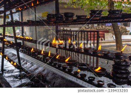 Abundant Clay Oil Lamps with Warm Flames Illuminate a Spiritual Setting, Creating a Sense of Peace and Traditional Serenity. Sri Lanka island in Asia. Abundant Clay Oil Lamps with Warm Flames Illuminate a Spiritual Setting, Creating a Sense of Peace and Traditional Serenity. Sri Lanka island in Asia. 139433293