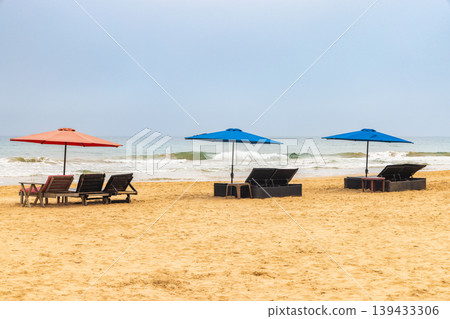 Inviting Beach Scene with Vivid Umbrellas and Loungers on Golden Sand, Highlighting a Relaxing Coastal Getaway. Sri Lanka island in Asia. 139433306