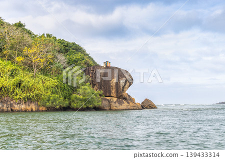 Lush Tropical Island Landscape with Rocky Coastline and Serene Blue Water Under a Cloudy Sky, Reflecting Nature's Tranquility. Sri Lanka island in Asia. 139433314