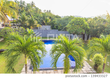 Inviting Backyard Oasis with Refreshing Swimming Pool and Lush Tropical Palms, Perfect for Relaxation and Vacation Getaways. Sri Lanka island in Asia. Inviting Backyard Oasis with Refreshing Swimming Pool and Lush Tropical Palms, Perfect for Relaxation and Vacation Getaways. Sri Lanka island in Asia. 139433327