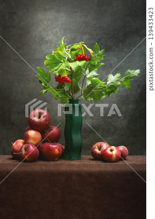 Still life with a branch of red viburnum in a vase and ripe apples Still life with a branch of red viburnum in a vase and ripe apples 139433423