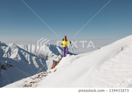 Person Conquering Snow Covered Mountain Summit Person Conquering Snow Covered Mountain Summit 139433873