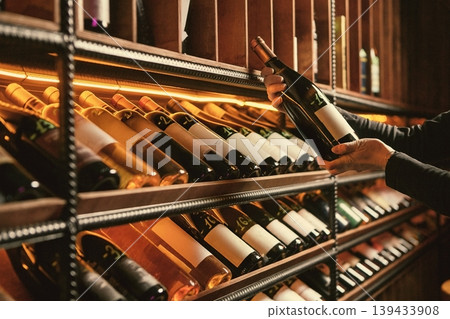 Pulling Wine Bottle from Wooden Rack Pulling Wine Bottle from Wooden Rack 139433908
