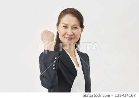 Woman pumping her fist against white background 139434167