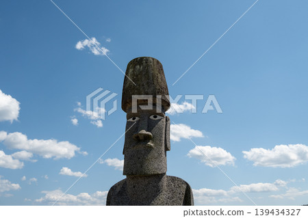 A scene of the Minamisanriku Moai statues, imbued with prayers for recovery from the earthquake, against a blue sky. 139434327