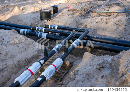 Underground insulated utility pipe network connections in trench for district heating project 139434353