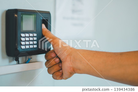 A person is using a fingerprint reader to access a building A person is using a fingerprint reader to access a building 139434386