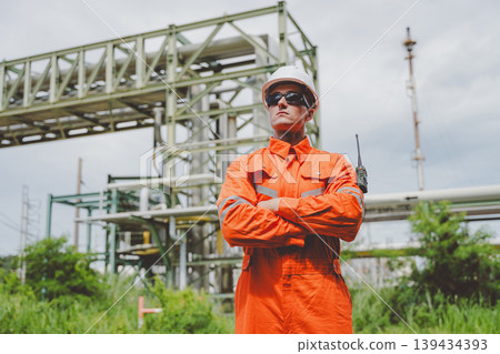 Engineer Standing at Oil Gas Pipeline Facility Using Radio for Communication Engineer Standing at Oil Gas Pipeline Facility Using Radio for Communication 139434393