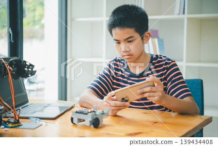 Asian boy learning and studying the work of technology robots.homeschool and science for tech project. playing childhood kids hobby leisure lifestyle people toys robotics technology. Asian boy learning and studying the work of technology robots.homeschool and science for tech project. playing childhood kids hobby leisure lifestyle people toys robotics technology. 139434408