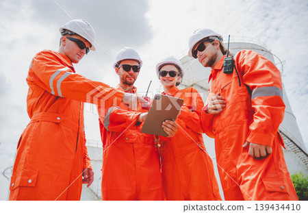 Oil and gas engineering team assesses tablet data and signals next actions during refinery inspection Oil and gas engineering team assesses tablet data and signals next actions during refinery inspection 139434410
