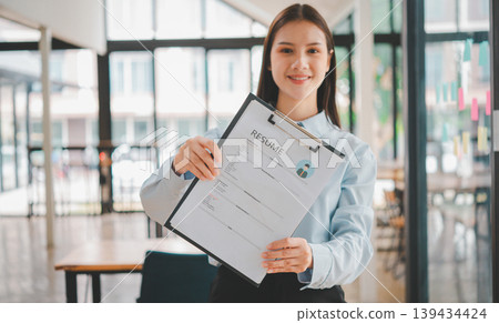 Asian young holding resume applying to apply for a job Asian young holding resume applying to apply for a job 139434424