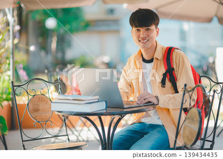 Happy smiling student with book in hand on campus while going to study for learning. Happy smiling student with book in hand on campus while going to study for learning. 139434435