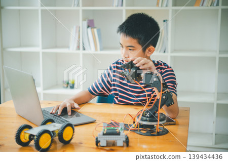 Asian boy learning and studying the work of technology robots.homeschool and science for tech project. playing childhood kids hobby leisure lifestyle people toys robotics technology. Asian boy learning and studying the work of technology robots.homeschool and science for tech project. playing childhood kids hobby leisure lifestyle people toys robotics technology. 139434436