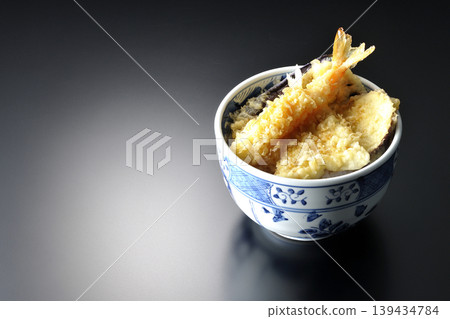 Tempura rice bowl photographed alone against a black background. Tempura rice bowl photographed alone against a black background. 139434784
