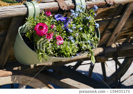 Yellow pansies with colorful bunting in a wooden planter, adding garden decor and bright seasonal accents. Yellow pansies with colorful bunting in a wooden planter, adding garden decor and bright seasonal accents. 139435173
