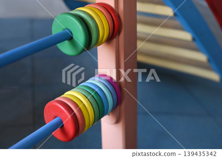 Colorful abacus beads on a preschool playground toy representing learning, childhood and early education play 139435342