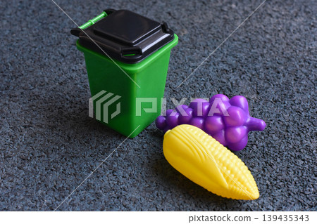 Toy food in a small green bin for play and recycling concepts 139435343