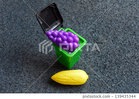 Toy food in a small green bin for play and recycling concepts 139435344