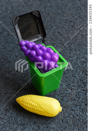 Toy food in a small green bin for play and recycling concepts Toy food in a small green bin for play and recycling concepts 139435345