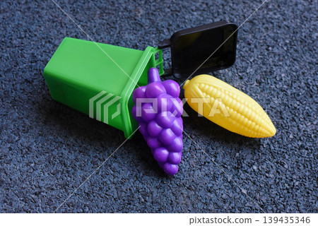 Toy food in a small green bin for play and recycling concepts Toy food in a small green bin for play and recycling concepts 139435346