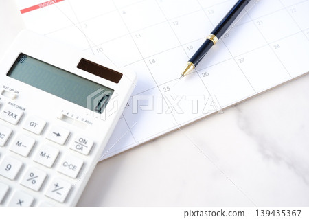 Payday - An image of someone staring at a calendar, tapping away on a calculator, eagerly awaiting the 25th, payday. Payday - An image of someone staring at a calendar, tapping away on a calculator, eagerly awaiting the 25th, payday. 139435367
