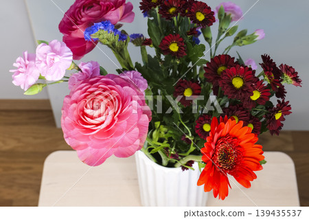 Bouquet of colorful flowers in a white vase, creating a vibrant botanical still life and decorative composition. Bouquet of colorful flowers in a white vase, creating a vibrant botanical still life and decorative composition. 139435537