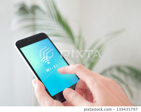 The Wi-Fi icon is displayed on the smartphone held in the hand. The screen is an original image. The Wi-Fi icon is displayed on the smartphone held in the hand. The screen is an original image. 139435797