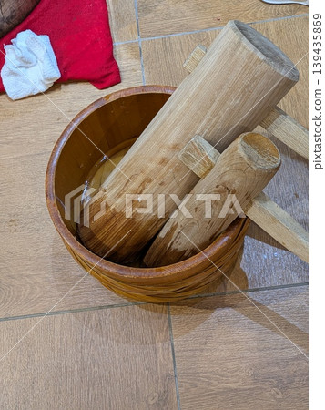 A pestle placed in a bucket of water A pestle placed in a bucket of water 139435869