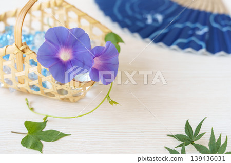 竹籃裡插著牽牛花(花),配上綠色的楓葉和一把扇子。 竹籃裡插著牽牛花(花),配上綠色的楓葉和一把扇子。 139436031
