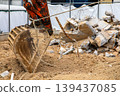 Construction industry image: excavator arm and rubble of demolished building. 139437085