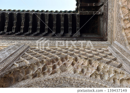 Carved stone gate arch, carved wooden architectural details, Medersa bou Inania, Fez, Morocco Carved stone gate arch, carved wooden architectural details, Medersa bou Inania, Fez, Morocco 139437149