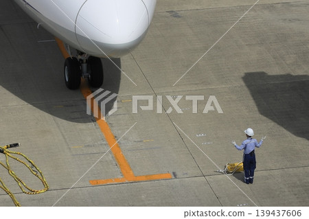 Ground handler guiding passenger plane Arrival of passenger plane Ground handler's hand signals 139437606