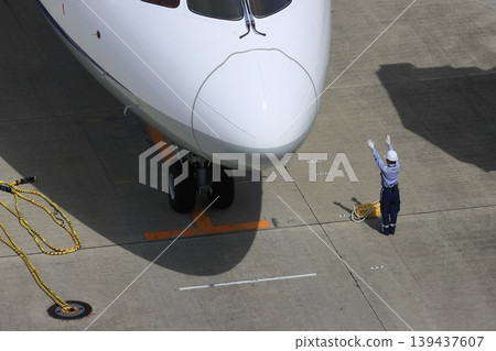 Ground handler guiding passenger plane Arrival of passenger plane Ground handler's hand signals Ground handler guiding passenger plane Arrival of passenger plane Ground handler's hand signals 139437607