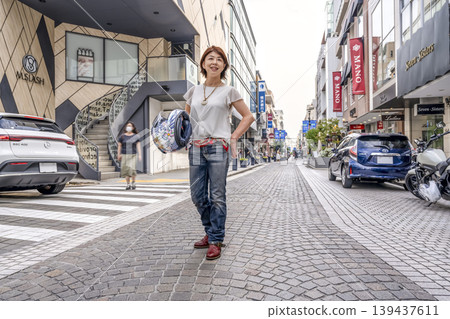 一位騎摩托車的女顧客來到元町商店街購物。 一位騎摩托車的女顧客來到元町商店街購物。 139437611