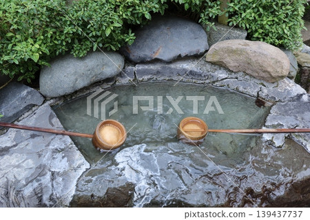 The sight of hot water flowing from the ladle at the purification fountain. The sight of hot water flowing from the ladle at the purification fountain. 139437737
