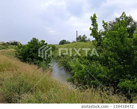 River Flowing Through Green Rural Landscape River Flowing Through Green Rural Landscape 139438472