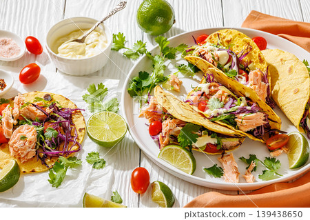 salmon tacos drizzled with sauce on a plate 139438650