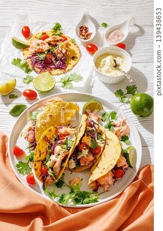 salmon tacos drizzled with sauce on a plate salmon tacos drizzled with sauce on a plate 139438653