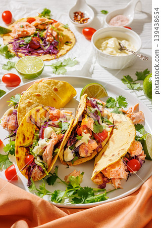 salmon tacos drizzled with sauce on a plate salmon tacos drizzled with sauce on a plate 139438654