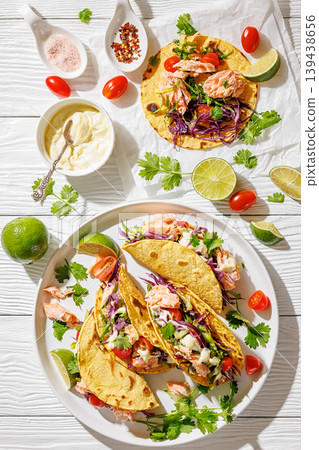 salmon tacos drizzled with sauce on a plate 139438656