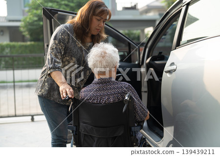 Caregiver help Asian elderly woman disability patient get in her car. Caregiver help Asian elderly woman disability patient get in her car. 139439211