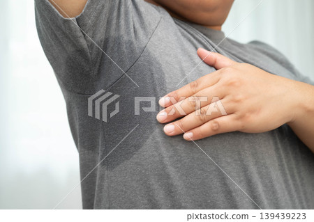 Sweaty underarms, Asian woman with sweat on clothes under armpit. Sweaty underarms, Asian woman with sweat on clothes under armpit. 139439223