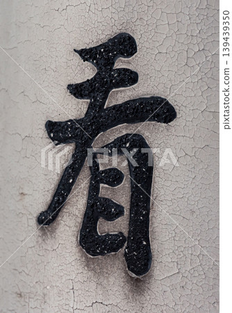 Chinese character 'kan' is attached to a wall with a textured surface in a city setting Chinese character 'kan' is attached to a wall with a textured surface in a city setting 139439350