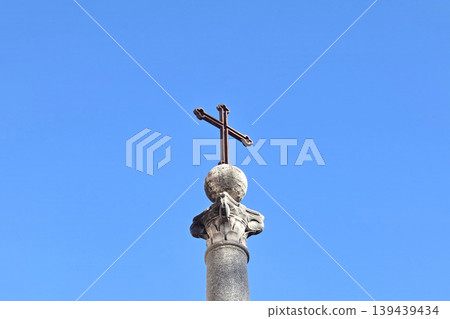 Religious Symbolism Against Blue Sky: Historic Cross on Pillar for Spiritual Design Religious Symbolism Against Blue Sky: Historic Cross on Pillar for Spiritual Design 139439434