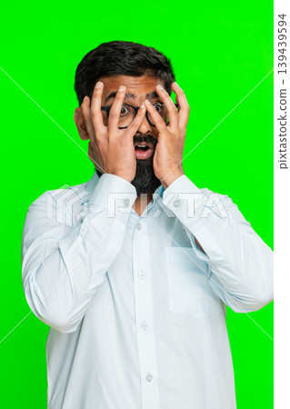 Indian man covering face with hands showing panic fear emotional stress moment of mental overload Indian man covering face with hands showing panic fear emotional stress moment of mental overload 139439594