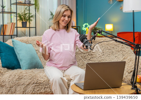 Pregnant woman sharing tips on laptop studio microphone video call laughing giving advice moms care 139439650