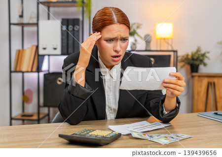 Young businesswoman checks bills with calculator sees negative balance worries about future expenses 139439656