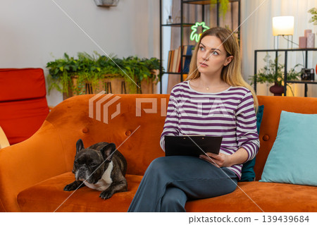 Middle-aged woman with dog reviews dog sitter contract reads fine print shows OK gesture and signs 139439684